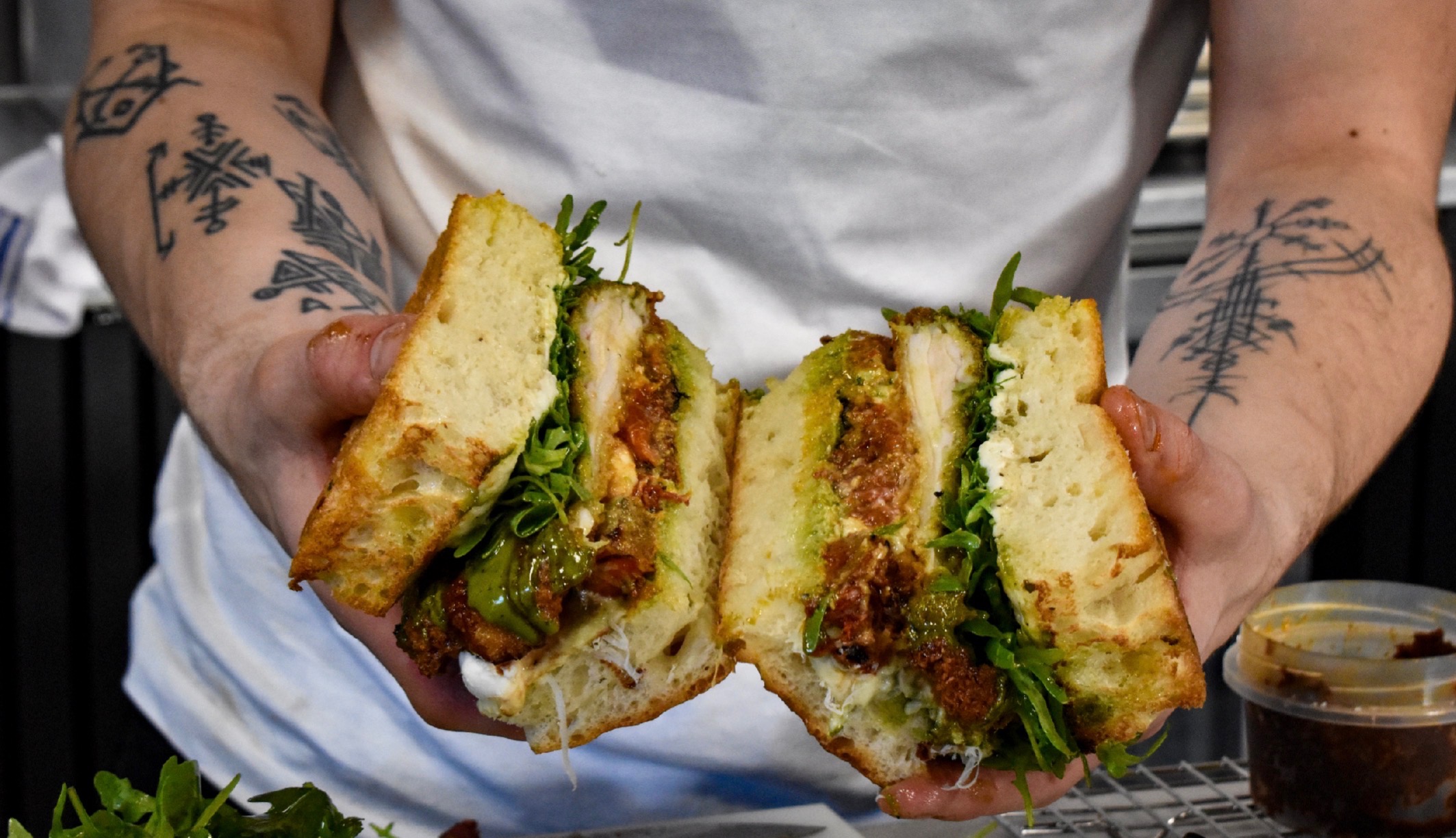 A Fjord focaccia sandwich cut in half, showing layered fillings and rocket.