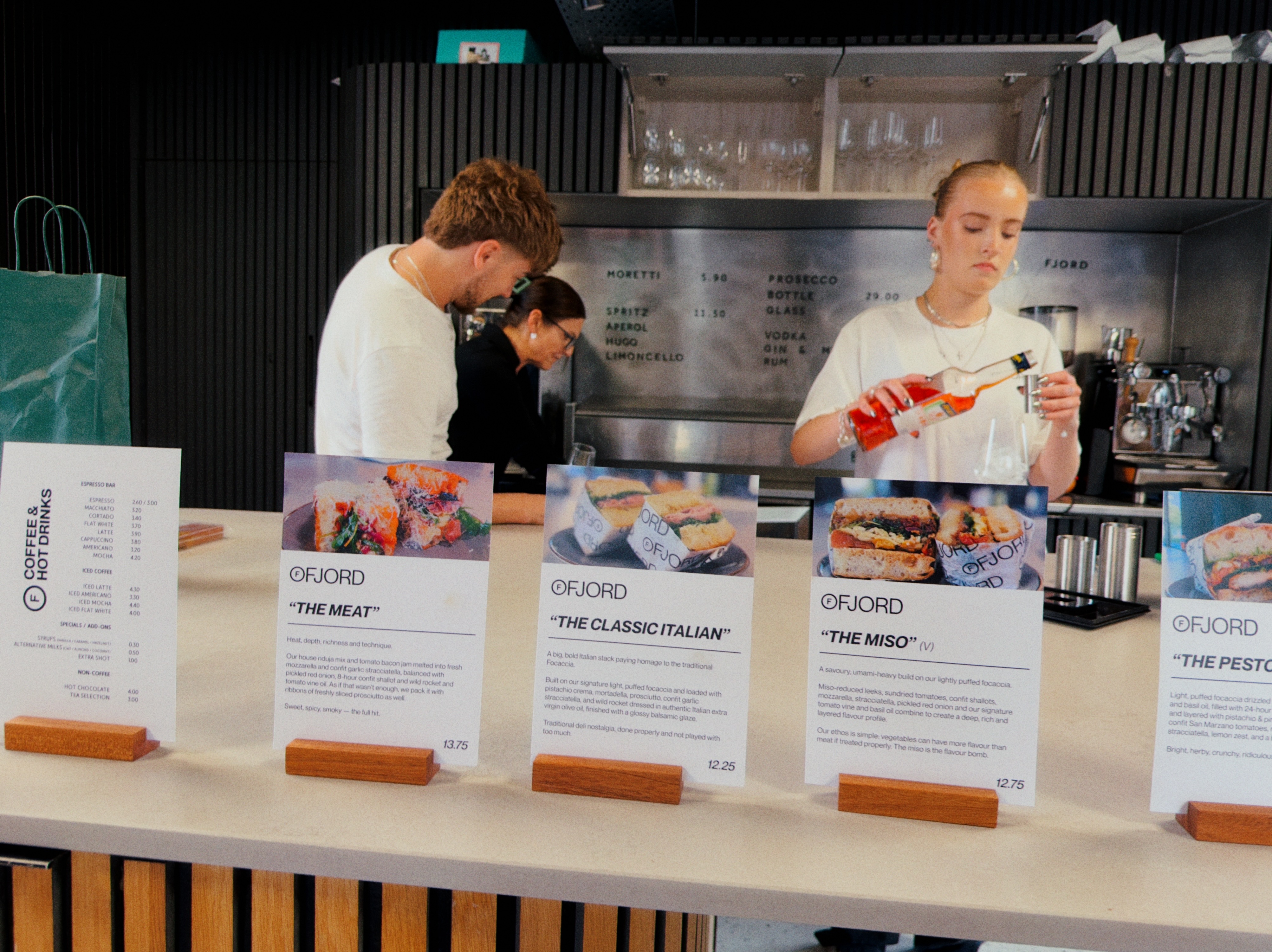 The Ruger Fjord team working behind the counter, with sandwich menu cards displayed along the front.